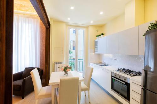 佛罗伦萨Flat Volturno- Florentine neighbourhood的厨房以及带桌椅的用餐室。