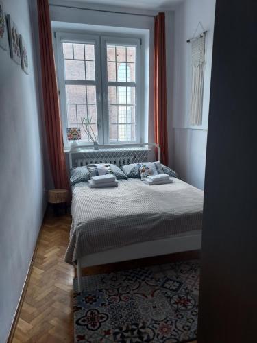 格但斯克Apartment in Old Town - view of Mariacki Church的一间卧室设有一张床和一个窗口