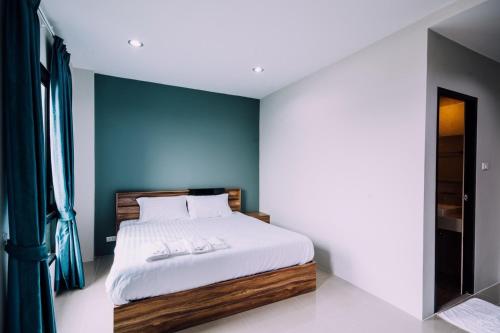 邦波The Living Hotel SamutPrakan的一间卧室配有一张蓝色墙壁的床