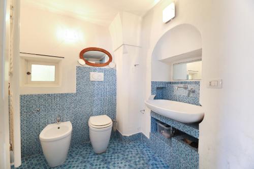 加利波利Case Vacanza Il Borgo Antico的蓝色瓷砖浴室设有卫生间和水槽