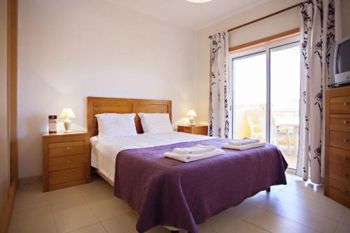 卡巴纳斯·德·塔维拉Apartamento Duja的一间卧室配有一张带紫色毯子的床