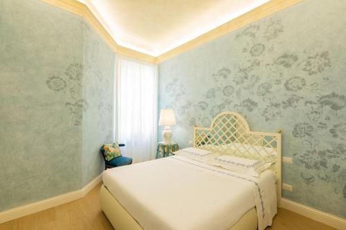 佛罗伦萨Flat Volturno- Florentine neighbourhood的一间卧室配有一张床和一张带花卉壁纸的墙壁
