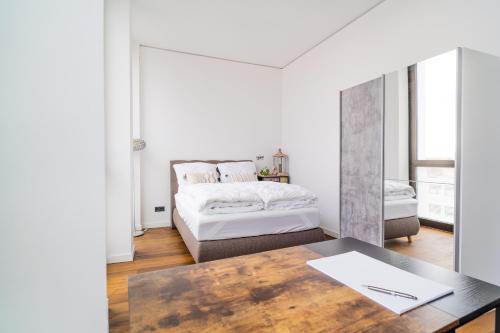 布伦瑞克Panorama Bliss - Luxus Apartment in Braunschweig's Altstadt的白色卧室配有床和桌子