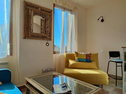 马赛Petit cocon à Mourepiane的客厅配有黄色沙发和镜子