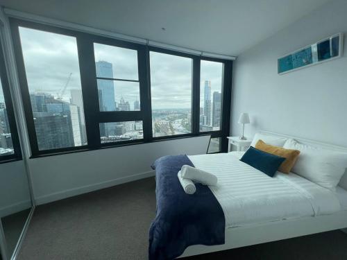 墨尔本Pars apartments - Melbourne Quarter- unique View of city and Yarra的配有大窗户的客房内的一张白色床