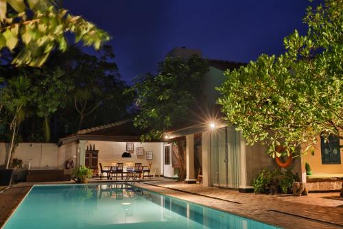 尼甘布Villa Hundira的夜间带游泳池的别墅