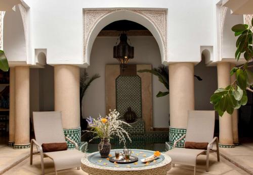马拉喀什Marrakech Riads, Angsana Heritage Collection的大堂设有桌椅,大楼