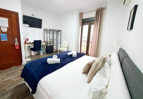塞维利亚Hotel Zaida的一间卧室配有一张带蓝白色床单的大床