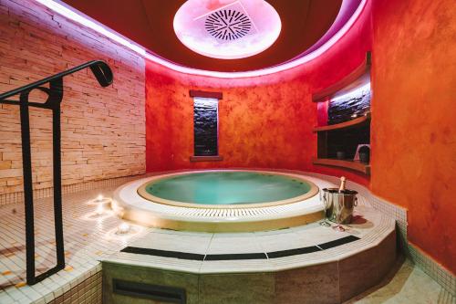 塔博尔派勒萨特酒店的红色天花板的客房内的按摩浴缸