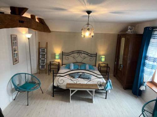 Saint-Germain-la-Ville佩里耶酒店的一间卧室配有一张床、两把椅子和一个吊灯