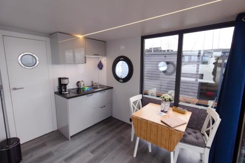 温德托尔夫Hausboot Fjord Aquila mit Dachterrasse in Wendtorf的小厨房以及带桌椅的用餐室。