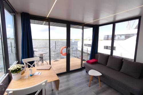 温德托尔夫Hausboot Fjord Aquila mit Dachterrasse in Wendtorf的客厅配有沙发和桌子