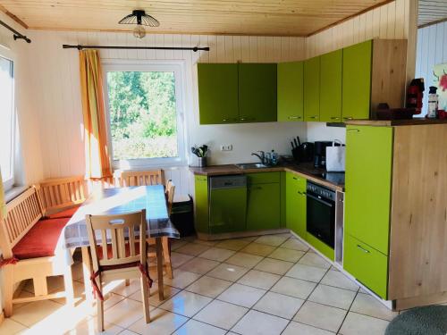 博克菲若博可姆和度假屋的厨房配有绿色橱柜和桌子