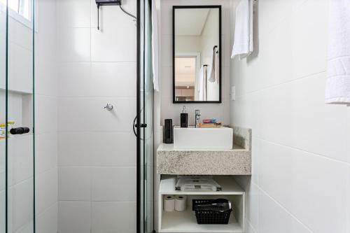 弗洛里亚诺波利斯Apartamentos completos ao lado da UFSC - NAVONA的白色的浴室设有水槽和淋浴。