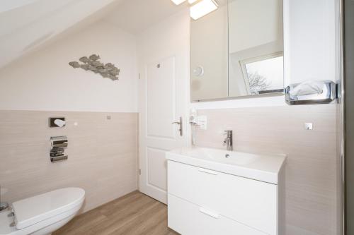 格斯塔特Gästehaus "Kleines Stadtidyll" -Zimmer und Apartments by Hotel Holsteiner Hof-的白色的浴室设有卫生间和水槽。