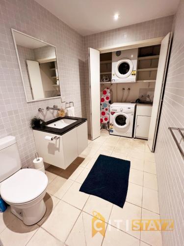 堪培拉Spacious 1bd Penthouse - Close to ANU的浴室配有卫生间、盥洗盆和洗衣机。