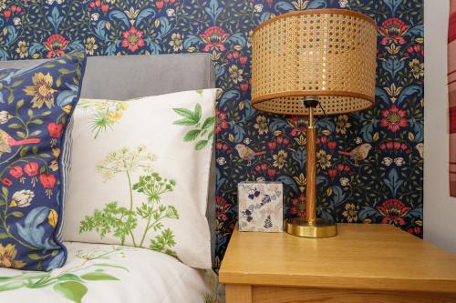 朴次茅斯Blue Sparrow House - parking的床头灯台上的一盏灯,床边有枕头