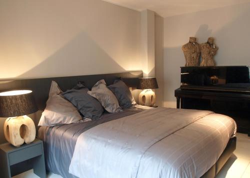 布兰肯贝赫Private House的一间卧室配有一张带两盏灯和一架钢琴的床。