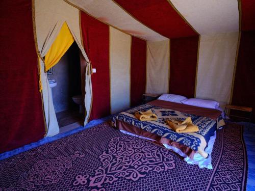 姆哈米德Chigaga Luxury Camp的一间帐篷内带两张床的卧室