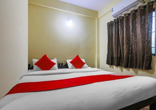 巴加Ocean Way Guest House的一间卧室配有一张带红色枕头的大床