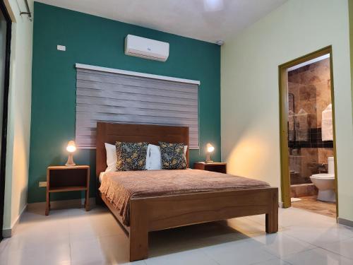 拉罗马纳Hotel La Casona MC的一间卧室配有一张床和两张台灯。