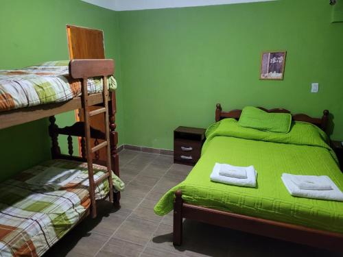 乌玛瓦卡Alto Independencia的一间卧室设有两张双层床和绿色的墙壁