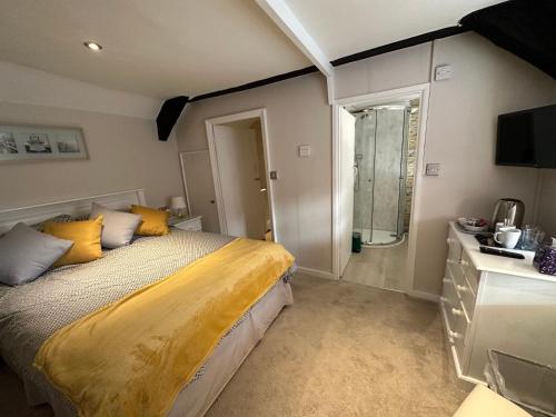 布里德波特Cottage en-suite room with private lounge的一间卧室配有一张带黄色床单的床和一扇窗户。