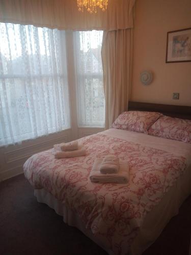 兰迪德诺Wedgwood Guest House的一间卧室配有一张床,上面有两条毛巾