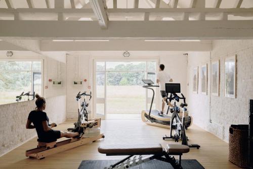 大雅茅斯Fritton Lake - The Clubhouse的健身房,有几个人在跑步机上锻炼