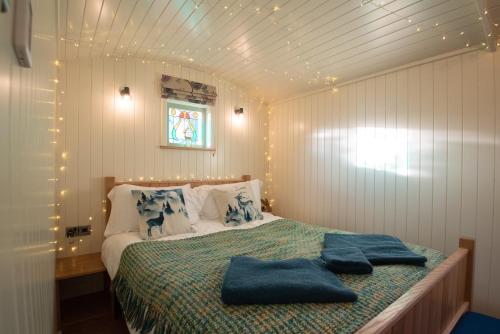 兰迪德诺Luxury Twin Shepherds Hut - Cosy & Romantic的一间卧室配有一张带2条蓝色毛巾的床