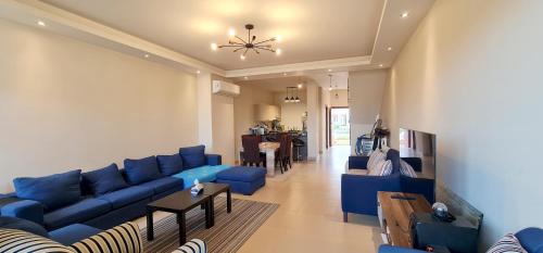 艾因苏赫纳Ain Sokhna 'Cosmopolitan'- Half-Board的客厅配有蓝色的沙发和桌子