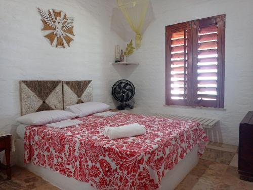 泰巴Casa dos Ximenes - Beira Mar da Taíba - Ótima localização的一间卧室配有一张带红白毯子的床