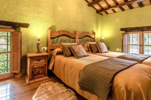 Sant Feliu de BuixalleuCatalunya Casas Stunning Costa Brava mountain retreat and 30kms away from the beach的一间卧室配有两张床和一张桌子及床头柜