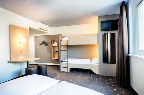 维也纳B&B Hotel Wien-Stadthalle的客房设有两张双层床和一张书桌。