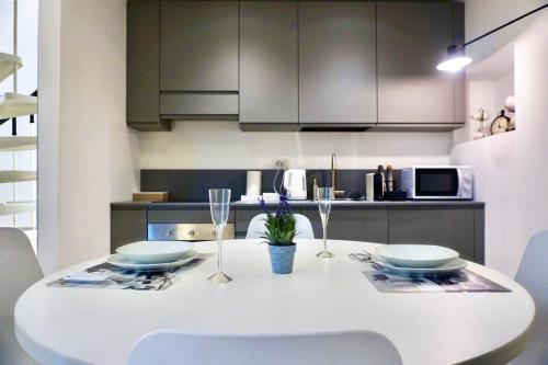 瓦雷泽LOFT 10的白色的餐桌、椅子和厨房