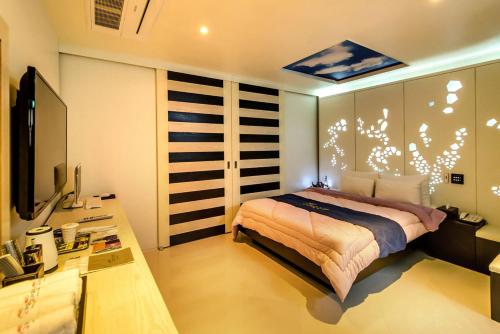 济州市Gyorae Drive-in Motel的一间卧室配有一张床、一张书桌和一台电视