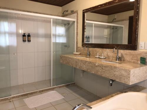伊塔齐米林加姆旅馆的一间带两个盥洗盆和淋浴的浴室
