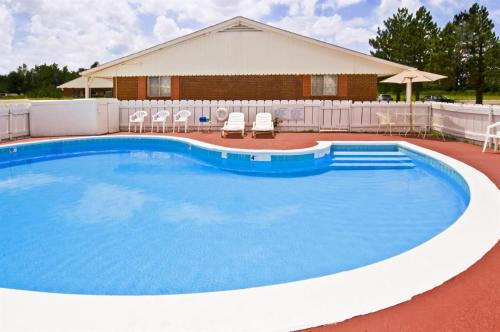 阿尔堪萨斯城Americas Best Value Inn Arkansas City的一座带椅子的大型游泳池和一座建筑