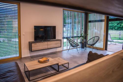 博希尼Residence Novak Bohinj的客厅配有平面电视和桌子。