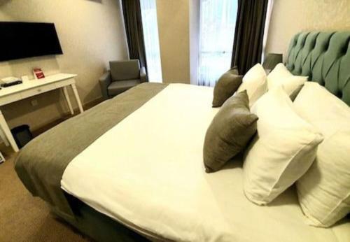 巴库Address Hotel Baku的卧室配有带枕头的大型白色床