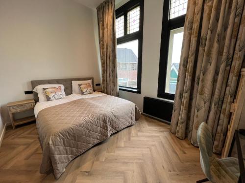 赞丹Boutique Hotel de Kade Zaandam-Amsterdam的一间卧室设有一张床和两个窗户。