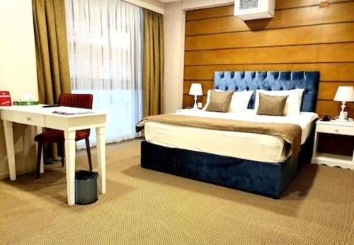 巴库Address Hotel Baku的配有一张床、一张桌子和一张桌子的酒店客房