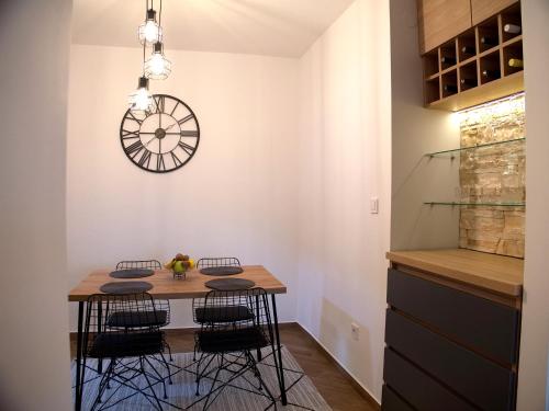 巴尔Adriatic Apartment的一间设有桌子和墙上时钟的餐厅