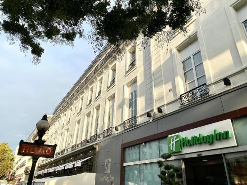 巴黎Holiday Inn Paris Opéra - Grands Boulevards, an IHG Hotel的前面有标志的大型白色建筑