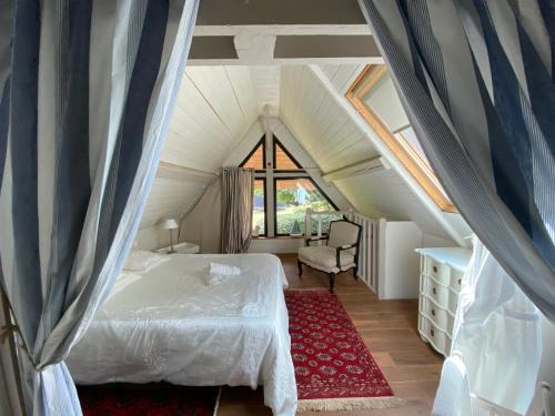 Néville林地自然保护区的阁楼卧室配有床和椅子