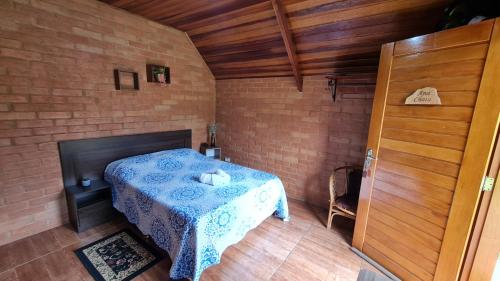 圣本图-杜萨普卡伊Chalés Maranata的卧室配有砖墙内的床铺