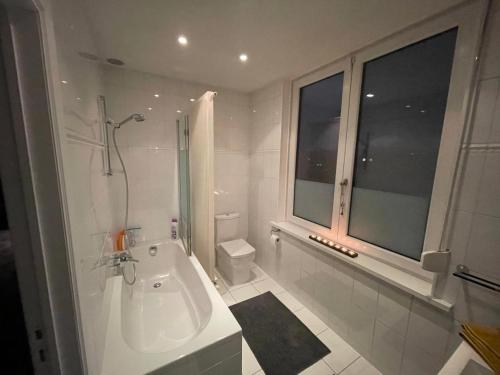 WemmelModern 1BR house near Heysel, Expo, Palais 12, Atomium, UZVUB et stade Roi Baudouin的白色的浴室设有浴缸和水槽。