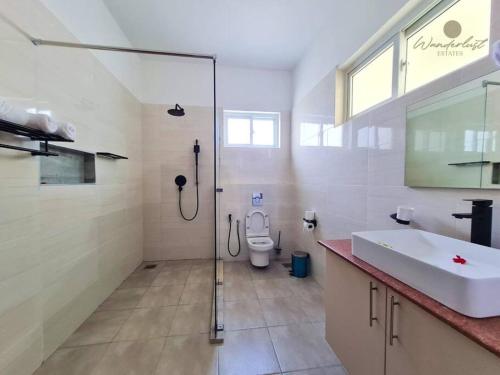 迪亚尼海滩Fiorella Beach House, Diani Beach的带淋浴、盥洗盆和卫生间的浴室
