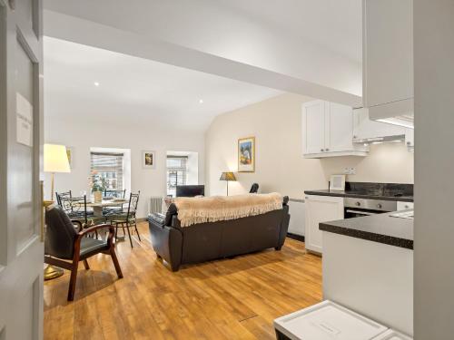 克利夫登Town centre apartment, Clifden的厨房以及带沙发和桌子的客厅。
