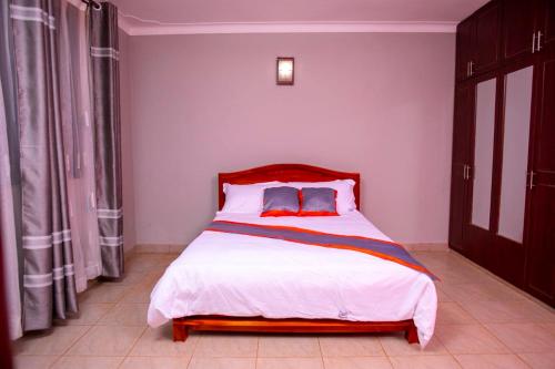 WakisoKaray Apartments的一间卧室配有一张大床和红色床头板